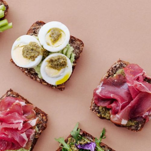 Delicious open-faced sandwiches with gourmet toppings including eggs, ham, and asparagus on rustic bread.