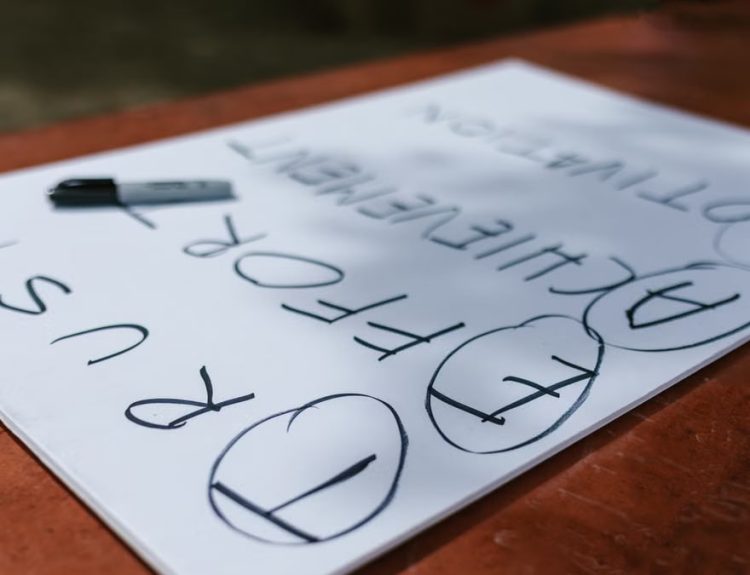 A paper with motivational words and markings placed outdoors on a table.